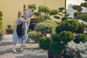 Women in a greenhouse. Lady working with a trees. Girl in a black apron.